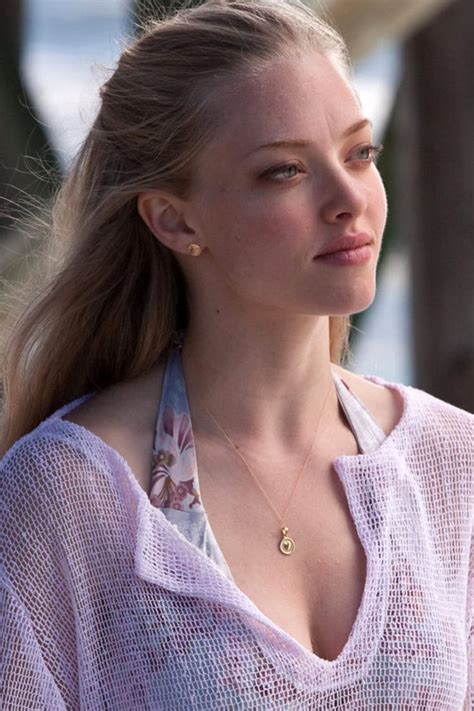 A Woman With Long Hair Wearing A White Shirt And Necklace Looking Off