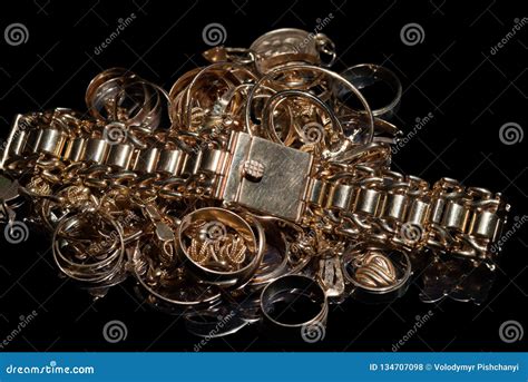 A Bunch Of Different Gold Jewelry On A Black Background Stock Photo ...