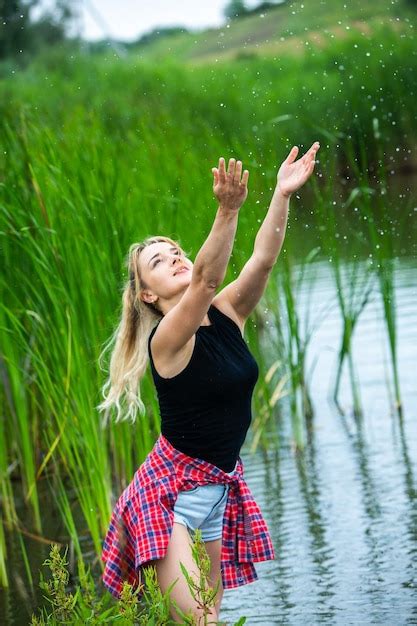 Das blonde Mädchen mit den langen Haaren amüsiert sich in der grünen