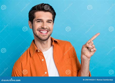 Photo Of Excited Positive Guy Wear Orange Shirt Pointing Finger Empty Space Isolated Blue Color