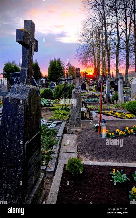 Tombstones And Silhouettes Of Crosses And Trees Against Sky At Sunset