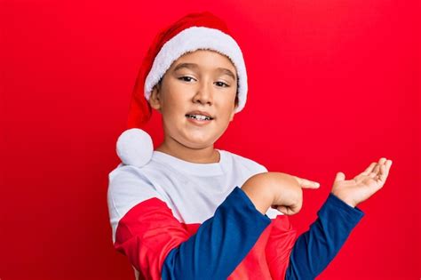 Premium Photo Little Boy Hispanic Kid Wearing Christmas Hat Amazed