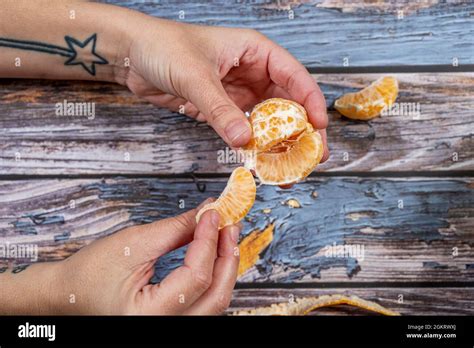Woman Hands With Magic Wand Tattoo Peeling A Tangerine To Eat The