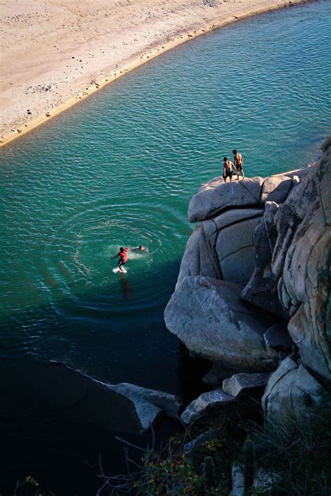 Two People Swimming Near Rocks In Huatulco Mexico