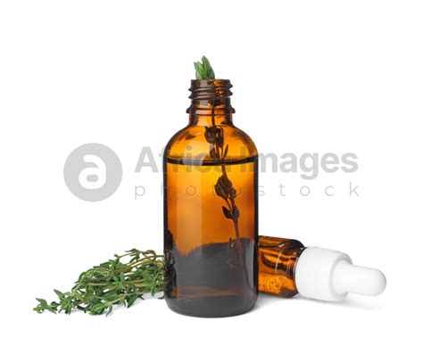 Bottles With Thyme Essential Oil And Fresh Herb On White Background