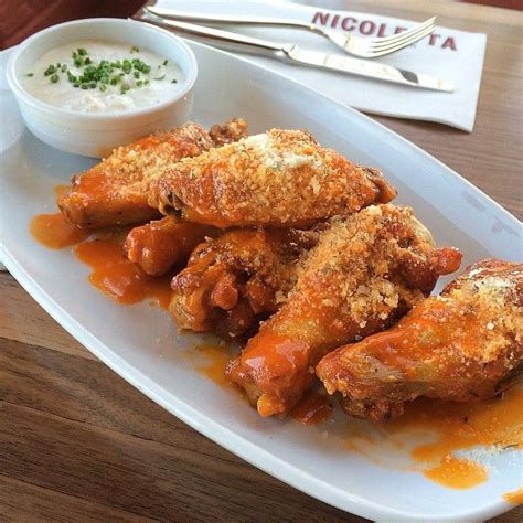 Chicken Wings Tossed In Honey And Calabrian Chile Glaze And Served With Blue Cheese Crema