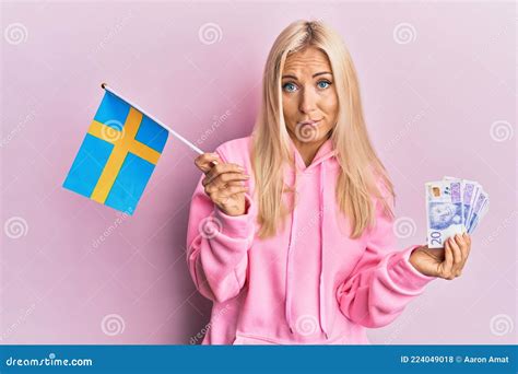 Junge Blonde Frau Mit Schwedischer Flagge Und Krone Banknoten Ahnungslose Und Verwirrte Ausdruck