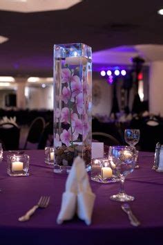 The Table Is Set With Purple Linens And White Napkins As Well As Candles