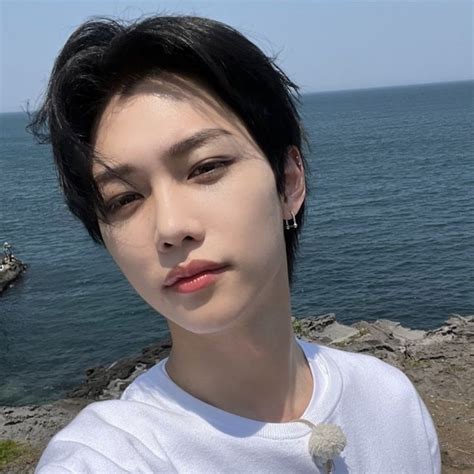 A Woman With Short Black Hair Standing Next To The Ocean