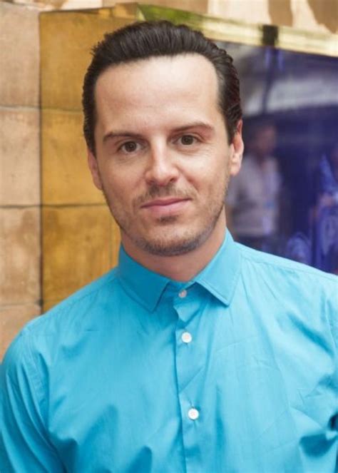 A Man Wearing A Blue Shirt And Tie Standing In Front Of A Building