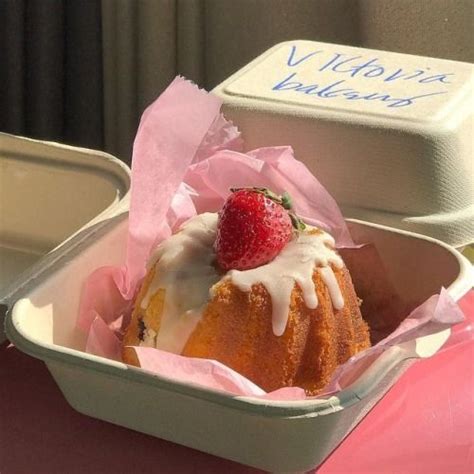 A Strawberry Bundt Cake With Icing And Strawberries In A Pink Paper