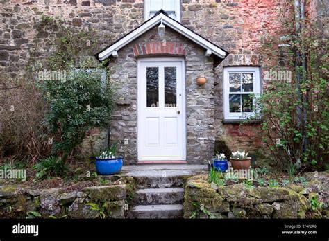 Exterior View Of White Front Door On Stone Cottage In Spring With White