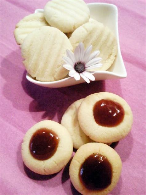 Some Cookies Are Sitting In A Bowl On A Table Next To A Flower And A Daisy