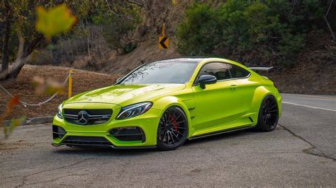 A Bright Green Mercedes Benz Coupe Is Parked On The Side Of The Road In