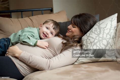 Pregnant Caucasian Woman Laying With Son High Res Stock Photo Getty