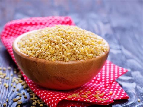 A Wooden Bowl Filled With Sesame Seeds On Top Of A Red And White