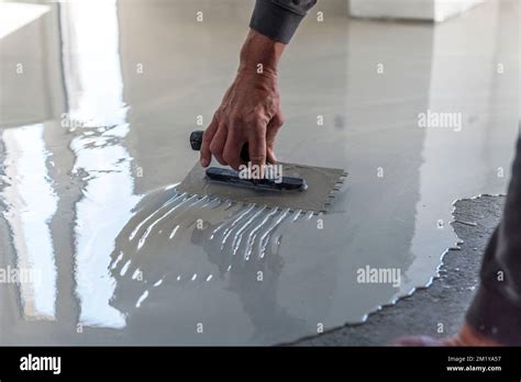 Los trabajadores de la construcción están pintando el piso usando el