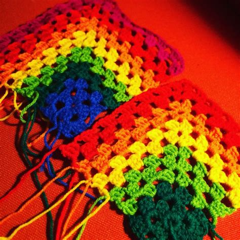 Three Crocheted Squares Are Sitting Next To Each Other On A Red Tablecloth