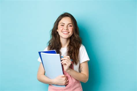 Feliz Joven Estudiante Sosteniendo Cuadernos De Cursos Y Sonriendo A La