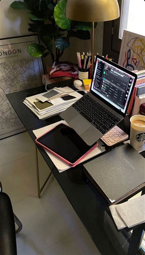 An Open Laptop Computer Sitting On Top Of A Desk Next To A Pile Of Papers