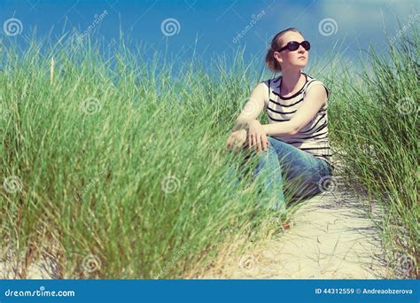 Femme S asseyant En Dunes De Sable Parmi La Détente Grande D herbe