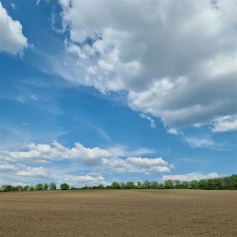 Un Campo Con Algunas Nubes Y Un Cielo Azul Foto Premium