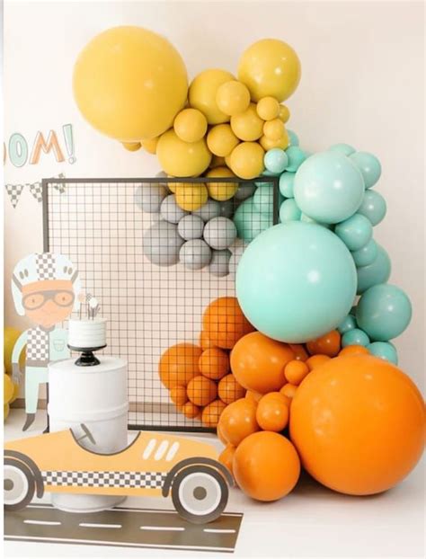 An Assortment Of Balloons And Decorations For A Race Car Birthday Party