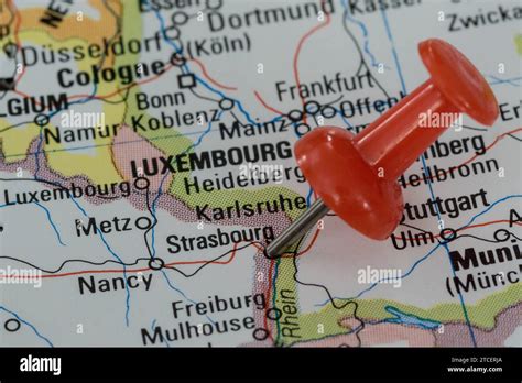 A Red Pin Stuck Into A Map Of Western Europe Pinpointing The Location