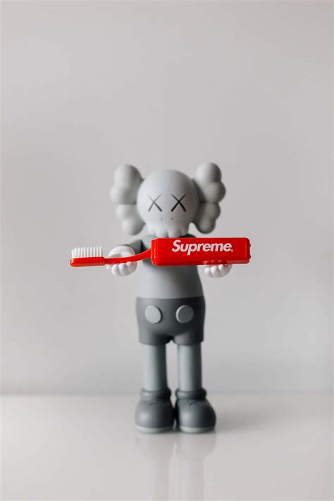 Download Caption Kaws X Supreme Street Art Collaboration Wallpaper