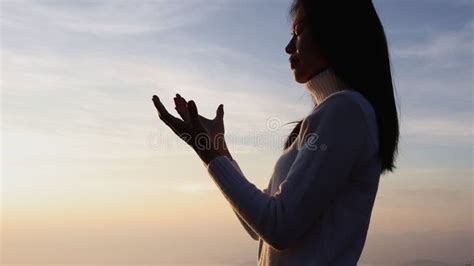Silhuette Young Woman Praying On The Mountain Arms Outstretched