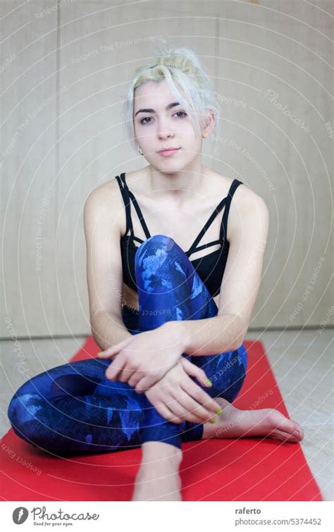 Gleeful Sporty Blonde Sitting Cross Legged On Exercise Mat A Royalty