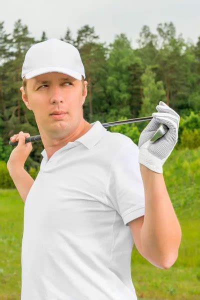 Golfer In A White T Shirt And A Baseball Cap With Golf Club Stock