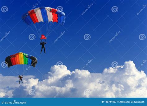 Two Parachutists Soar On Colorful Parachutes Across The Boundless Blue