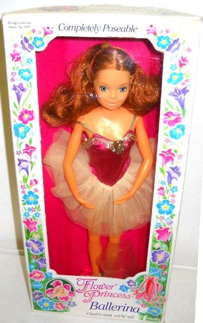 A Barbie Doll In A Pink And Gold Ballerina Dress With Flowers On Its Head