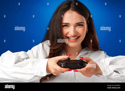 Beautiful Brunette Girl Playing Video Games Against Blue Background Stock Photo Alamy