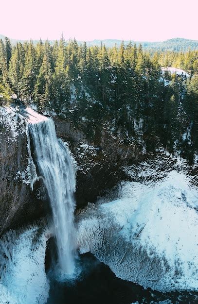 Disparo Vertical De Una Hermosa Cascada Y Un Bosque En Invierno Foto