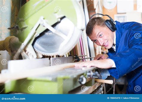 Vigorous Workman Cutting Wooden Planks Using Circular Saw Stock Photo