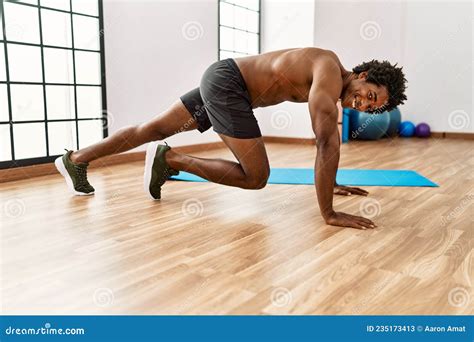 Young African American Man Training Abs Exercise At Gym Stock Image