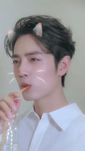 a young man is holding a straw in his mouth