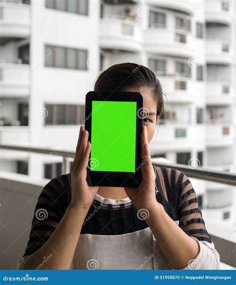 Woman Holding Tablet In Her Hands With Blank Green Screen Stock Photo