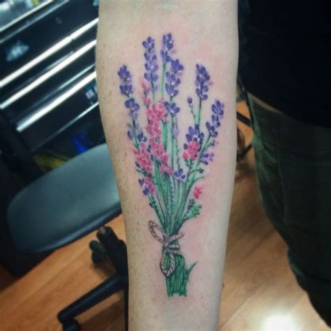 A Woman S Arm With Flowers On It And A Bow Around The Wrist Tattoo