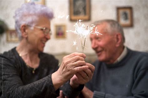 Happy Senior Couple Celebrating With Sparklers By Stocksy Contributor