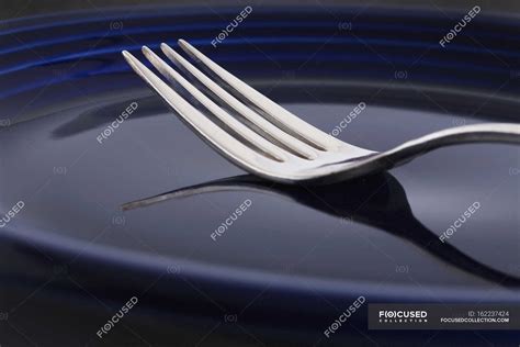 Closeup fork with reflection on blue plate — objects, stainless - Stock ...