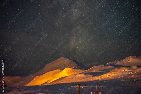 The Milky Way visible over the yellow-lit mountains of Antarctica Stock ...