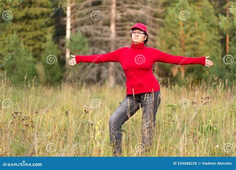 Beautiful Mature Women Doing Gymnastics In A Clearing In A Coniferous