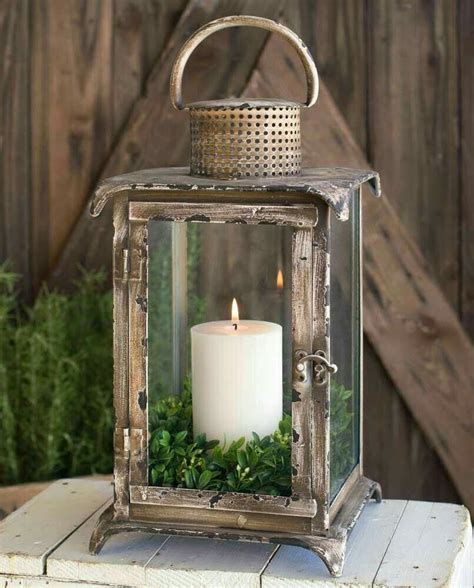 An Old Lantern With A Candle And Greenery In It