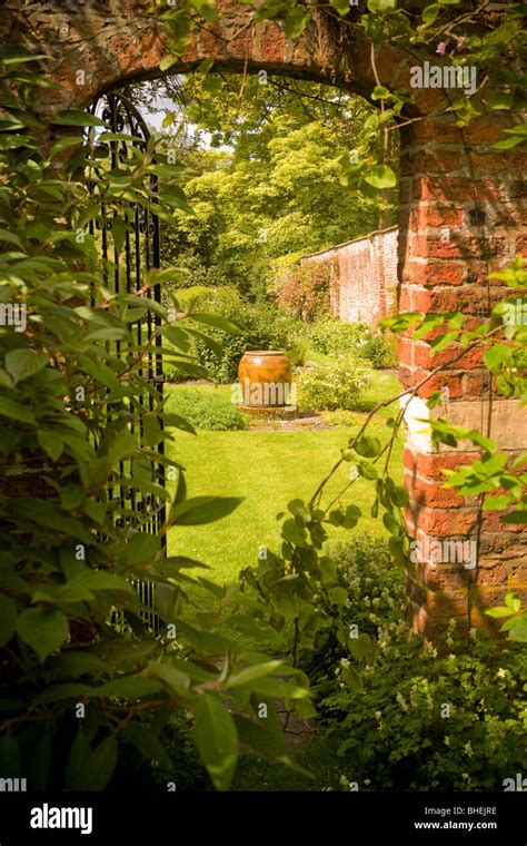 Partially Open Wrought Iron Gate Leading Into A Secret Garden Uk Stock