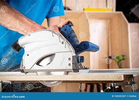 Carpenter With Hand Circular Saw At Work Closeup Of Sawing Cut Of Pine