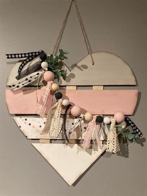 A Wooden Heart Hanging On The Wall Next To A Plant And Other Items That