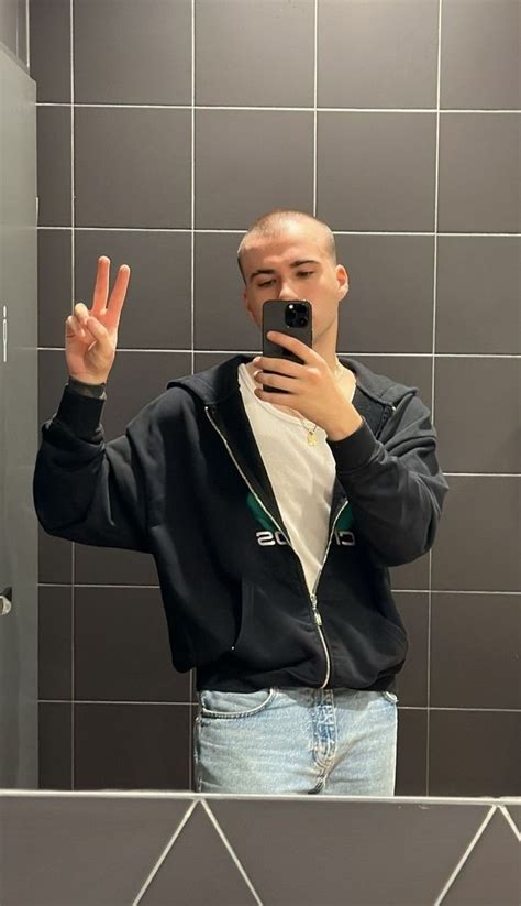 A Man Taking A Selfie In Front Of A Bathroom Mirror With His Cell Phone